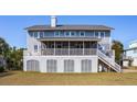 Back of house featuring gray siding, large screened porch, and deck at 3019 Brownell Ave, Sullivans Island, SC 29482