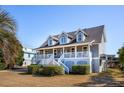 Two-story house with gray siding, white trim, and a wraparound porch, side view at 3019 Brownell Ave, Sullivans Island, SC 29482