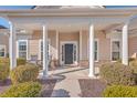 Inviting front porch with rocking chairs and columns at 369 Waterlily Way, Summerville, SC 29486