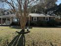 Brick ranch house with a tree in front and a well manicured lawn at 4765 S Constellation Dr, North Charleston, SC 29418
