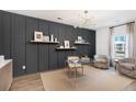Modern home office with dark gray accent wall, built-in shelves, and a glass desk at 563 Richfield Way, Summerville, SC 29486