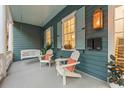 Peaceful front porch with a swing and comfy adirondack chairs at 66 Warren St # Entire Property, Charleston, SC 29403