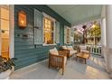 Relaxing front porch with wicker chairs and a wooden coffee table at 66 Warren St # Entire Property, Charleston, SC 29403