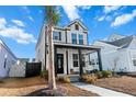 Two-story house with white siding, black accents, welcoming porch, and palm tree at 111 Crimson St, Summerville, SC 29486