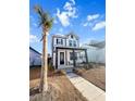 Two-story home with white siding, black accents, welcoming porch, and palm tree at 111 Crimson St, Summerville, SC 29486