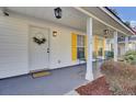 Inviting front porch with white columns, yellow shutters, and seating at 125 Trickle Dr, Summerville, SC 29483