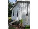 House side view, showing a white door and gray vinyl siding at 206 Dukes St, Saint George, SC 29477
