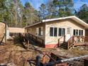 Tan house with ramp access, wooden steps, and detached shed at 218 Cat Hole Ln, Branchville, SC 29432