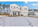 Two-story house with a white garage door and porch swing, freshly covered in snow at 261 Firewheel Ct, Summerville, SC 29486