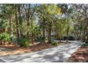 Long driveway leading to a two-story house nestled among trees at 2908 Old Drake Dr, Seabrook Island, SC 29455