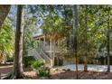 Two-story house with light green siding, a wraparound porch, and a staircase at 2908 Old Drake Dr, Seabrook Island, SC 29455