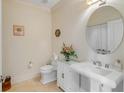 Neat half bathroom with pedestal sink and round mirror, alongside a toilet and floral arrangement at 355 Cooper River Dr, Mount Pleasant, SC 29464