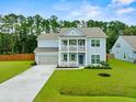 Two-story light blue house with gray roof, two-car garage, and landscaped yard at 4041 Oxeye Loop, Johns Island, SC 29455