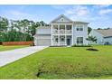 Two-story light blue house with gray roof, two-car garage, and landscaped yard at 4041 Oxeye Loop, Johns Island, SC 29455