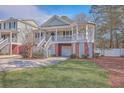 Two-story home with brick and siding, a porch, and a two-car garage at 4816 8Th Tee Dr, Hollywood, SC 29449