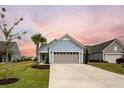 Charming light blue house with gray garage door and landscaping at 531 Switchgrass Dr, Summerville, SC 29486