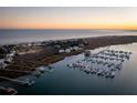 Aerial view of waterfront homes and a marina with many boats at sunset at 67 W We 10Th St # A-8, Folly Beach, SC 29439