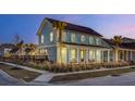Two-story light blue house with a front porch, landscaping, and palm trees at 711 Blueway Ave, Summerville, SC 29486
