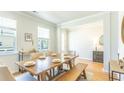 Open concept dining room with hardwood floors, neutral walls and large windows at 126 Lilac Grove Way, Summerville, SC 29486