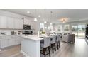 Open kitchen with white cabinets, island seating, and stainless steel appliances at 132 Lilac Grove Way, Summerville, SC 29486