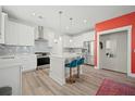 Modern white kitchen with island, stainless steel appliances, and teal barstools at 1669 Indy Dr, North Charleston, SC 29405