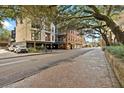 Building exterior on tree lined street with brick sidewalks at 21 George St # 114, Charleston, SC 29401