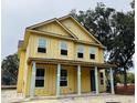 Two story home with light yellow siding, a covered porch, and light blue columns at 2976 Lodge Berry Ln, Johns Island, SC 29455