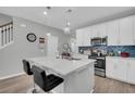 Modern kitchen with white cabinets, quartz countertops, and an island at 396 Painted Lady Ln, Goose Creek, SC 29445