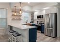 Modern kitchen with white cabinets, marble countertops and a farmhouse sink at 7311 Indigo Palms Way, Johns Island, SC 29455