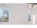 Bright bedroom with ceiling fan, tray ceilings, and tree views from large windows at 0 United Dr, Huger, SC 29450