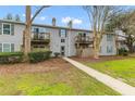View of a two-story condo building featuring balconies and a well-manicured lawn at 1402 Camp Rd # Apt 9D, Charleston, SC 29412