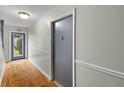 Hallway with wood floor leading to an exterior door and the condo's main door at 1402 Camp Rd # Apt 9D, Charleston, SC 29412