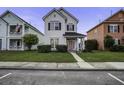 A two-story home with tidy lawn and sidewalk; surrounded by other colorful homes at 221 Trillium Ave, Summerville, SC 29483