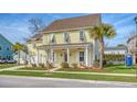 Attractive two-story yellow house with white columns, shutters, and a two-car garage at 2725 Battery Pringle Dr, Johns Island, SC 29455