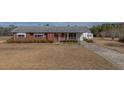 Ranch-style home with a brick facade, covered porch, and mature landscaping at 2830 Wire Rd, Saint George, SC 29477