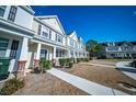 Street view of townhomes featuring tidy landscaping, welcoming entrances, and classic design at 393 Flyway Rd, Goose Creek, SC 29445