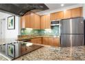 Kitchen with stainless appliances, granite counters, and a vibrant backsplash at 5804 Palmetto Dr # A-401, Isle of Palms, SC 29451