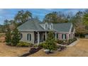 Two-story house with gray siding and brick accents, nestled on a wooded lot at 788 Awendaw Lakes Blvd, Awendaw, SC 29429