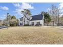 Two story white house with black shutters and a spacious yard at 7897 Sabalridge Dr, North Charleston, SC 29418
