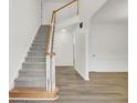 Open staircase with wood railing and neutral carpeting at 7897 Sabalridge Dr, North Charleston, SC 29418