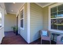 Inviting covered front porch features a cozy seating area, perfect for relaxing outdoors at 8623 Woodland Walk, North Charleston, SC 29420