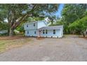 Charming two-story home with light blue siding, a new roof, and a gravel driveway surrounded by mature trees at 1787 Hay Rd, Johns Island, SC 29455
