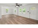Bright living room features new wood flooring, white walls, large windows, and a ceiling fan at 1787 Hay Rd, Johns Island, SC 29455