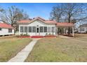 Charming home featuring a metal roof, covered porch, and well-maintained lawn at 222 E Main St, Moncks Corner, SC 29461
