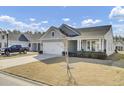 A beautiful single-story home with a two-car garage, a well-kept lawn, and a car parked in the driveway at 376 Tupelo Lake Dr, Summerville, SC 29486