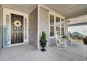 Inviting front porch with rocking chairs, decorative wreath, and stylish accents with a 'Welcome' sign at 376 Tupelo Lake Dr, Summerville, SC 29486