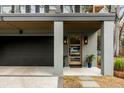Home's entrance with a light wood door, modern lighting, and a view of the attached two car garage at 915 Dill Ave, Charleston, SC 29412