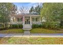 Charming home with a welcoming front porch, American flag, blue shutters, and well-maintained landscaping at 1013 Barfield St, Charleston, SC 29492