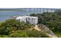 Aerial view of condo building with water access, surrounded by lush trees and plants at 108 Fairbanks Oak Aly # 201, Charleston, SC 29492