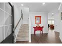 Inviting foyer features hardwood floors, stairs to the second floor, a red table, and decor at 1105 Mossy Rock Dr, Summerville, SC 29485